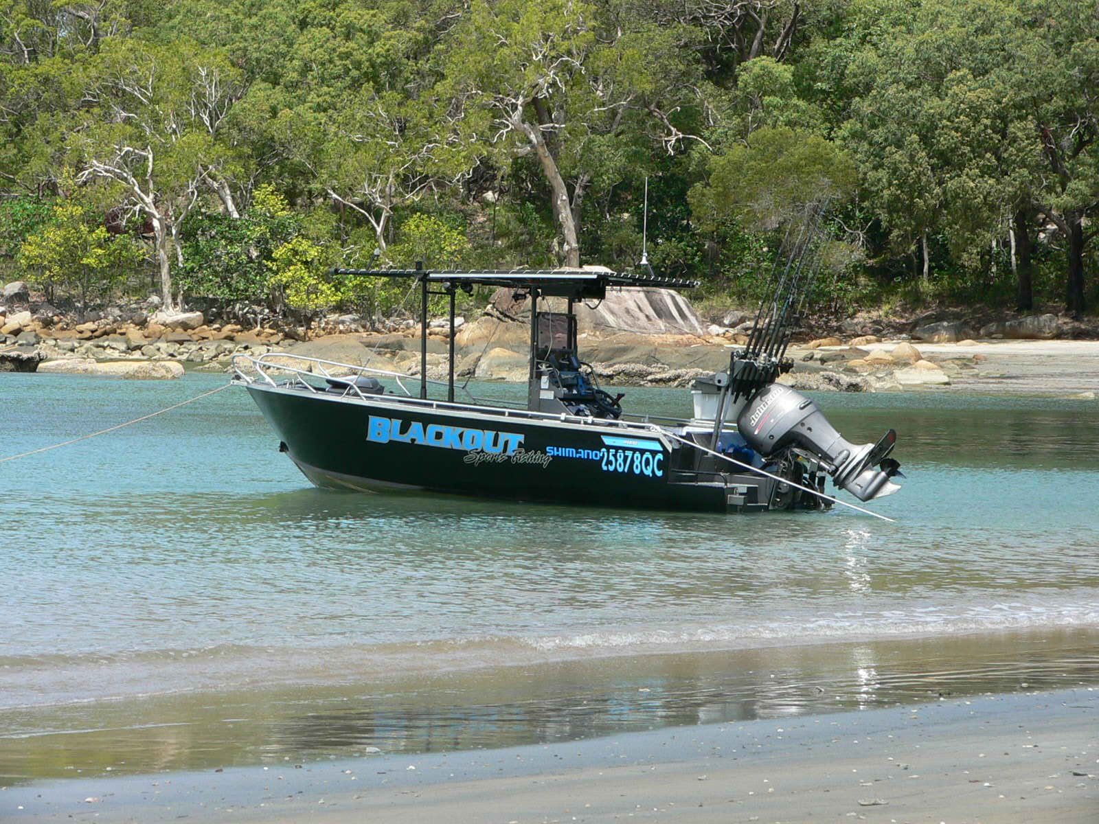 The Blackout boat anchored off a beach